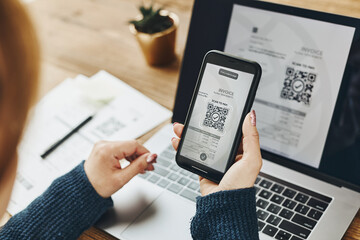 Woman scanning QR code from invoice to make payment using fast secure payment system and smartphone code reader. Business woman paying bills using express payment technology. Paying expenses online