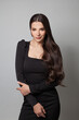© millaf (Nemchinova) - Fashion beauty portrait of a beautiful young brunette woman with long wavy hair wearing black cocktail dress posing