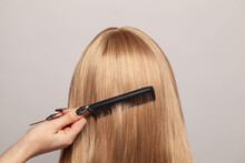 Hairdresser Combing Hair Of Blonde Woman Closeup