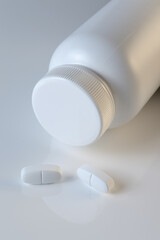 Wall Mural - white plastic medicine jar and two white pills. light background