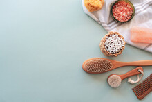 Natural cosmetics, wooden brushes, ear cleaning sticks, comb, sponge, soap and pink himalayan salt on light blue table. Beauty, spa and wellness. Zero waste concept. Top view, flat lay, copy space