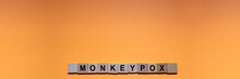 MONKEYPOX. Word Written On Square Wooden Tiles With An Orange Background. Zoonotic Viral Disease That Can Infect Non-human Primates, Rodents And Some Other Mammals. Smallpox. Monkey Pox. Virus.