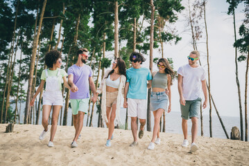 Sticker - Full body photo of positive cheerful fellows hold arms walking sand beach spend free time outdoors