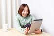 © garage38 - 部屋でタブレット端末を使う女性