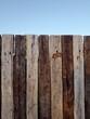 © CarlosJose - Cerco de tablones de madera de Quebracho sudamericano en el campo rural, de color blanco y marròn alineados en forma de valla, forma un bello diseño abstracto natural con fondo del cielo azul