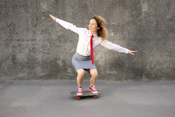 Wall Mural - Funny businesswoman riding skateboard outdoor