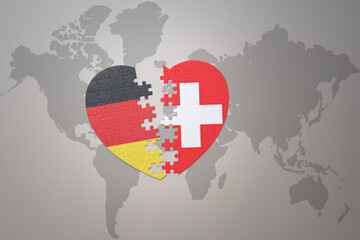 Wall Mural - puzzle heart with the national flag of switzerland and germany on a world map background. Concept.