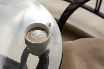 Wall Mural - Ceramic cup of aromatic coffee on glass table outdoors, above view. Good morning