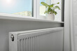 Modern radiator under window at home. Central heating system