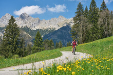 Nice Senior Woman Riding Her Electric Mountain Bike On The Old Gaicht Pass Road From Lech Valley Up To The Tannheim Valley In Tyrol, Austria