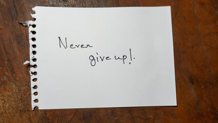 Hand written motivational word Never give up. lifestyle motivational positive words written on a wooden background. Business, signs, symbols, concepts. Copy space.