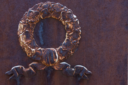 old rusty iron plate with laurel wreath decoration