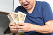 © koumaru - 札束を持つ笑顔のシニア男性