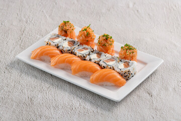 Poster - Fresh made sushi mix. Different kinks of salmon sushi served on white plate. Studio shoot on slated background.