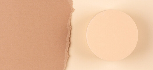 Abstract composition with empty round podium platform for product presentation and curve shaped torn paper edge on brown beige background. Top view