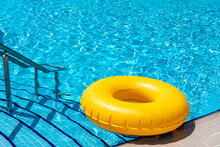 Yellow Ring Floating In Refreshing Blue Swimming Pool