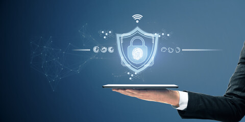 Poster - Security and internet safety concept with digital tablet on man hand and glowing digital lock symbol with fingerprint inside on abstract background