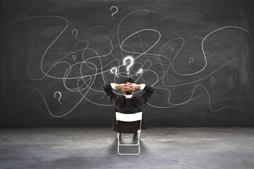 Poster - Find solution and making choice concept with back view on businessman sitting on chair and looking at blackboard with question marks and chaotically written lines