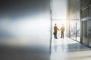 Sticker - Business partnership concept with man handshaking in sunny office hall with city view and blank blurry wall with copyspace. Mock up, close up