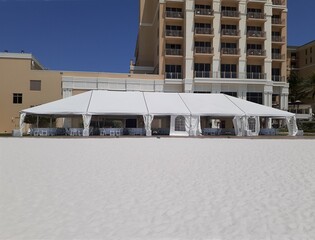 a large white events or entertainment tent on the beach