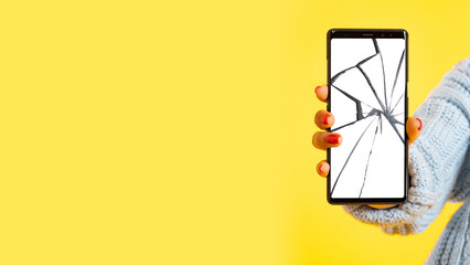 Poster - A woman's hand holds a smartphone with a broken screen. Cracks on the smartphone screen. A broken mobile phone. Electronics repair service center. Replacement of gadget screens.