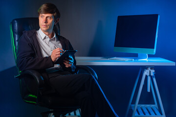 Poster - Man is holding an electronic tablet and thinking. Writer ponders a new story. A man takes notes in a tablet computer. Man with tablet sits in a leather chair. The person next to the desk with the PC.