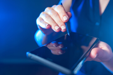 Poster - Woman uses a smartphone with a stylus. Close-up of a woman using her mobile phone. A girl with an electronic device. Female hands with smartphone. Electronic gadgets. A smartphone with a touchscreen