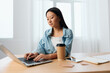 © SHOTPRIME STUDIO - Focused serious young Asian cute female businesswoman type tax report on laptop in light office interior. Employee freelancer work at home. Lady corporation leader concept. Copy space Banner Offer