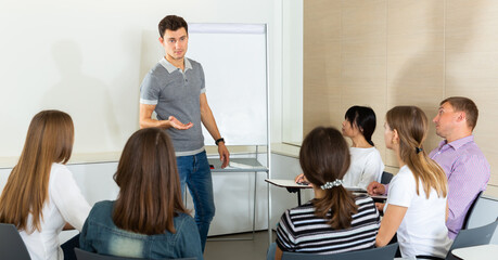 Wall Mural - Young man sharing business ideas with colleagues in meeting room. Concept of teamwork..