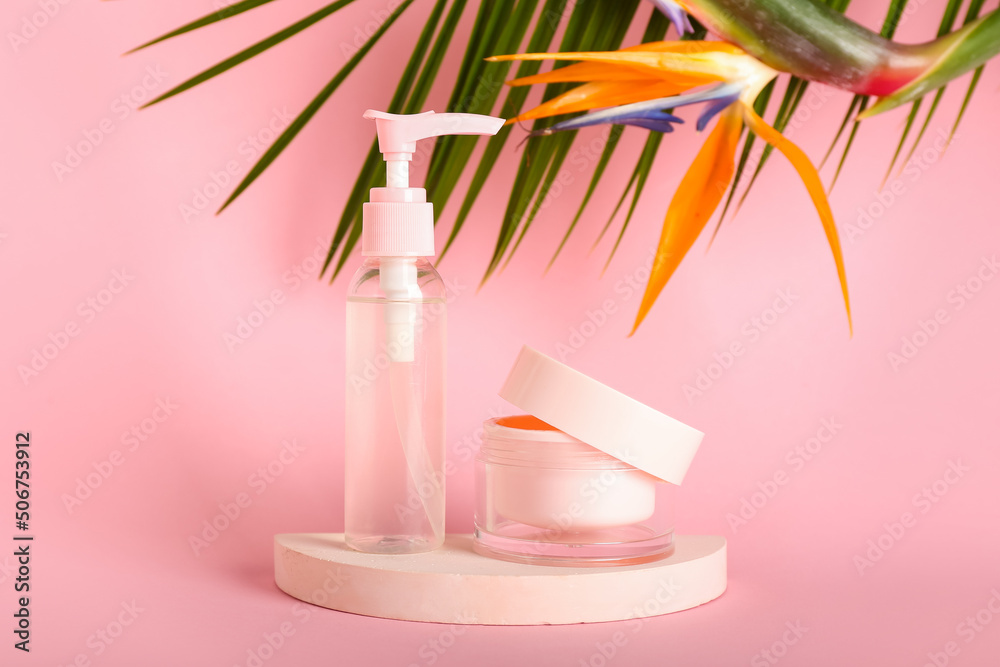 Cosmetic products and strelitzia flowers on pink background