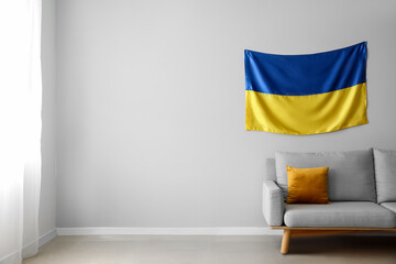 Wall Mural - Modern sofa and flag of Ukraine hanging on light wall