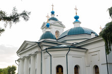 A Large White Church With Blue Domes And Golden Crosses.