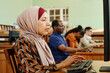 © pressmaster - Young adult Middle Eastern woman wearing hijab working on computer in university library