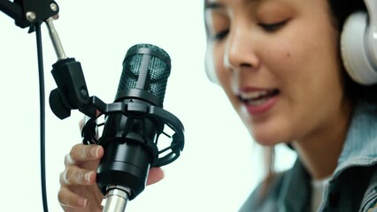 Wall Mural - Close-up condenser microphone of content creator woman host streaming his a podcast on laptop with headphones interview conversation at home broadcast studio. Blogger recording voice over radio.