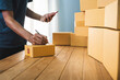 © 22January - Young entrepreneur business owner work at home, small business startup receive order client and take note working with report and pack the product on purchase delivery online to sending destination.
