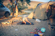 funny child on rug does exercises near the tents, rest as savages with children and tents, lifestyle. Real photo with many camping items