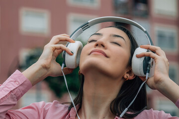 Sticker - relaxed young woman with headphones on the street