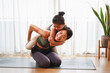 © chayantorn - Mom teaching her kid to yoga pose and exercise together on yoga mat in living room at home