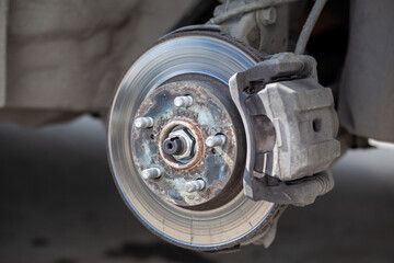 Poster - Disc brake of the vehicle for repair, in process of new tire replacement. Car brake repairing in garage.Suspension of car for maintenance brakes and shock absorber systems. Replacement of brake pads.