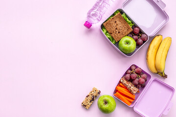 Student meal in purple lunch boxes filled with sandwich and fruits