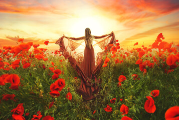 fantasy goddess woman queen in red silk dress. Happy girl princess praying hands raised to sky, bright magic light divine sun art dramatic sunset. Summer nature Field poppies flowers, Back rear view