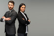 Young man and woman standing back-to-back with crossed hands against grey background. Concept of partnership in business