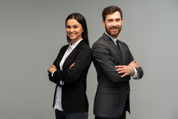 concept of partnership in business. young man and woman standing back-to-back with crossed hands aga