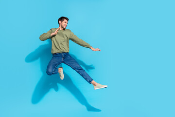 Poster - Full size portrait of sportive excited person jump air battle hands legs kick isolated on blue color background