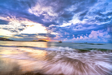 Wall Mural - Beautiful sunrise on the beach waves lapping at the shore of the soft great to welcome the new day