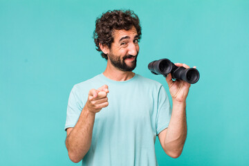 Wall Mural - young adult hispanic crazy man with binoculars. searching concept