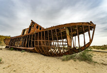 Boats Cemetery Around The Aral Sea. Rusty Carcasses In The Desert Dunes Where Once There Was Water.