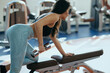 © chika_milan - A sportswoman is doing exercises for the biceps in a gym.