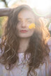 © Mariana - curly hair woman with blue eyes and yellow flower on face