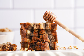 Wall Mural - Slices of Chocolate banana bread with walnuts on a marble board and ingredients on a grey neutral background with creative lighting